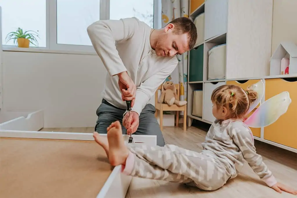 Father assembling kid bed drawer